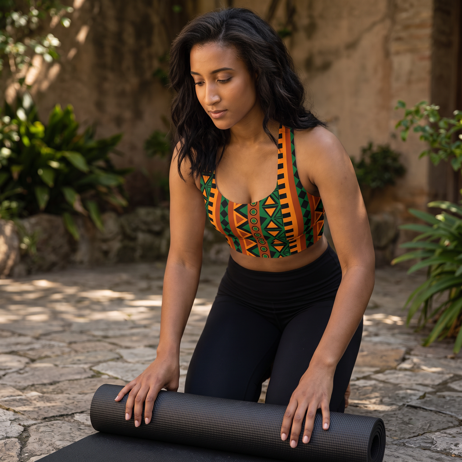 Woman rolling out a yoga mat in the Mzansi Recycled Longline Sports Bra